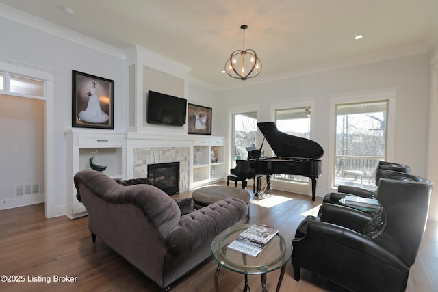 living room with visible vents, a healthy amount of sunlight, a stone fireplace, and wood finished floors