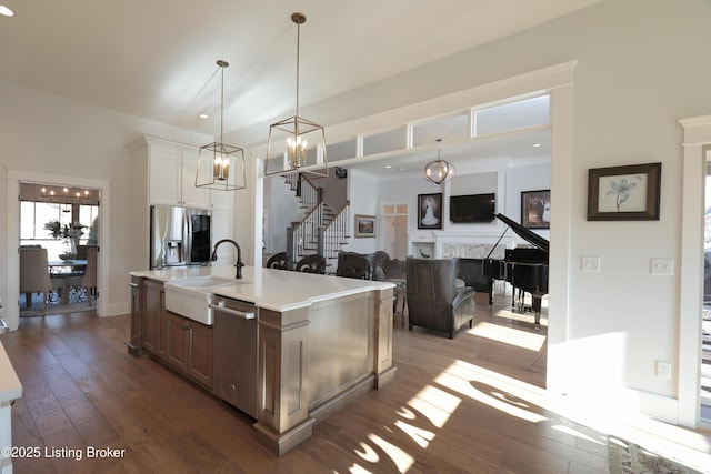 kitchen featuring appliances with stainless steel finishes, hardwood / wood-style flooring, a fireplace, and a sink