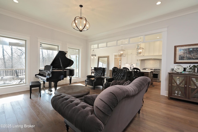 living area featuring recessed lighting, wood finished floors, an inviting chandelier, and ornamental molding