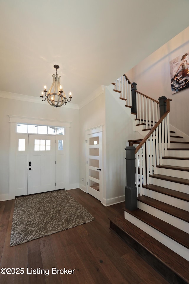 foyer with stairway, a notable chandelier, wood finished floors, and crown molding