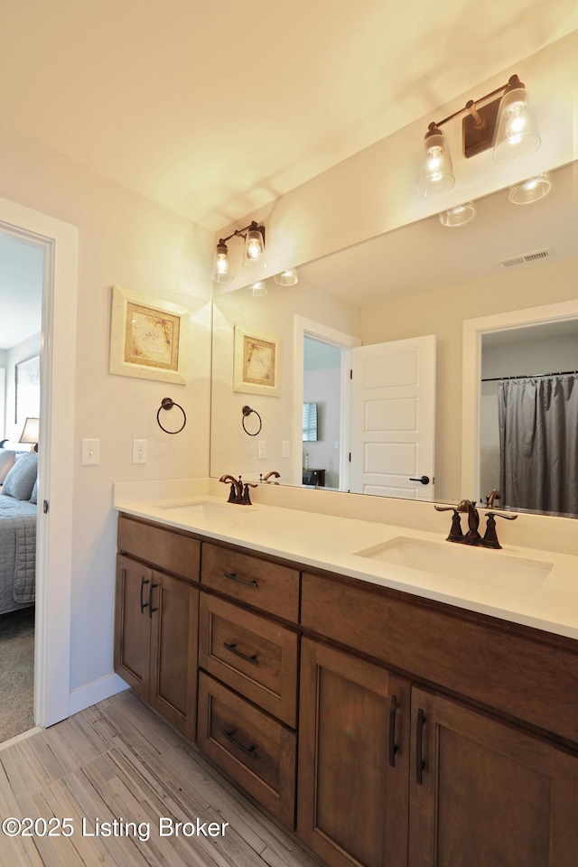 ensuite bathroom with double vanity, visible vents, ensuite bathroom, and a sink