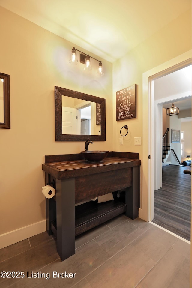 bathroom with wood finished floors, baseboards, and a sink