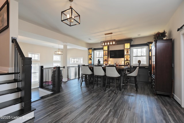 dining room featuring stairway, baseboards, an inviting chandelier, and dark wood-style flooring