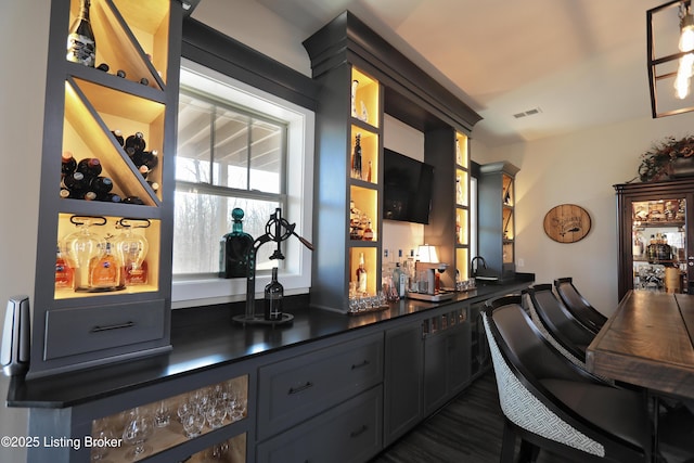 bar featuring indoor wet bar and visible vents