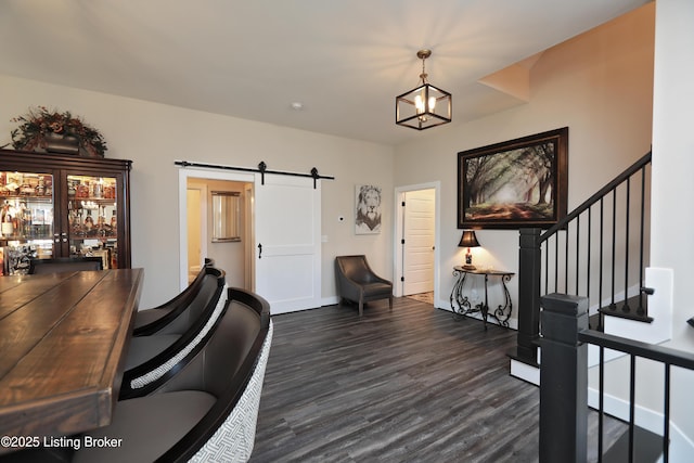 office area with dark wood-style floors, a notable chandelier, baseboards, and a barn door