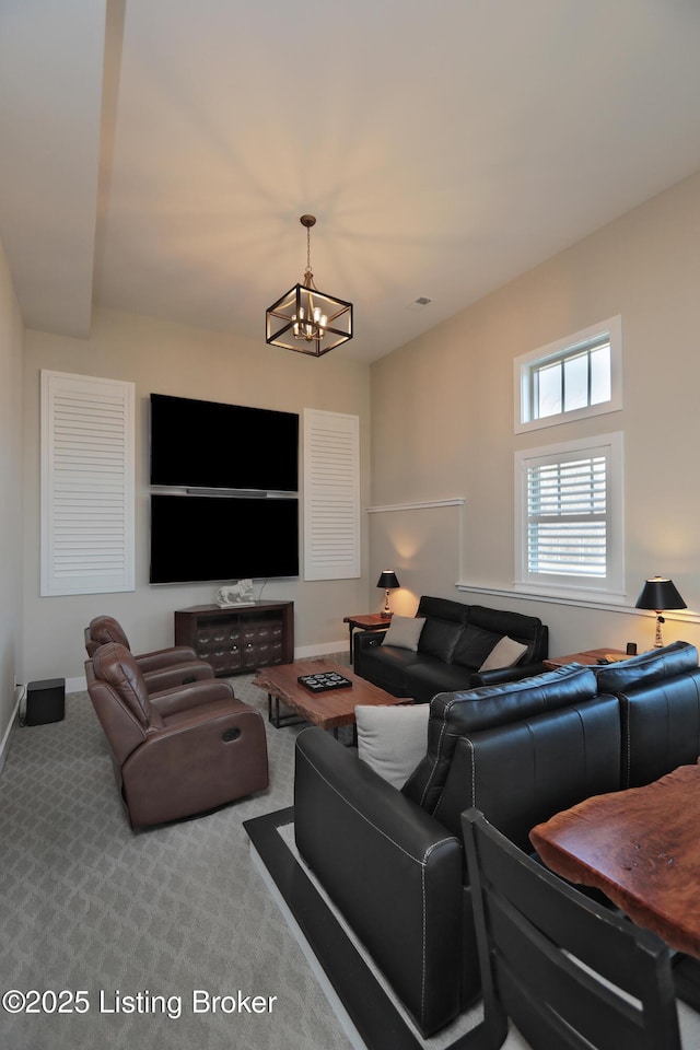 carpeted living room featuring a notable chandelier and baseboards