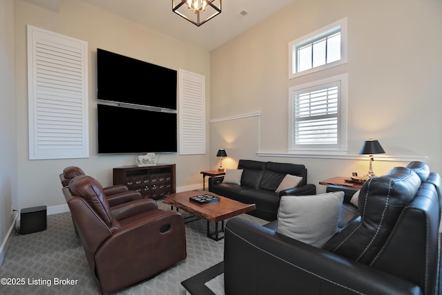 living area featuring carpet flooring, visible vents, baseboards, and a chandelier