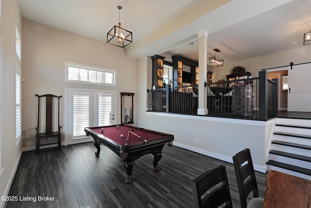 game room with pool table, baseboards, a barn door, wood finished floors, and a notable chandelier