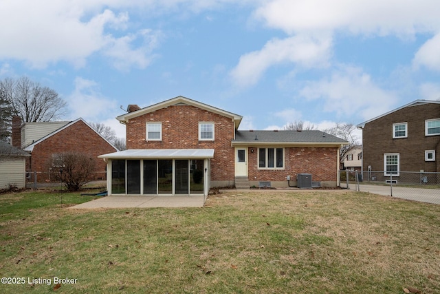 rear view of property with a yard, brick siding, cooling unit, and a sunroom