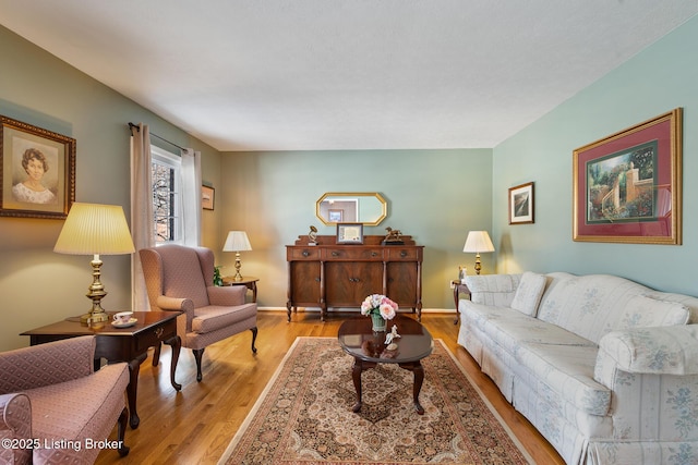 living area with baseboards and wood finished floors