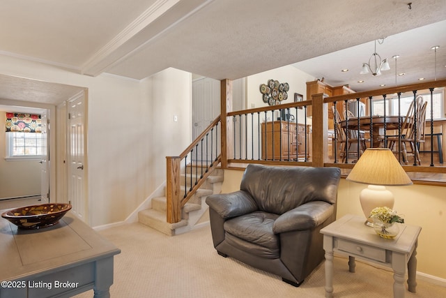 carpeted living room with beam ceiling, stairway, ornamental molding, a chandelier, and baseboards