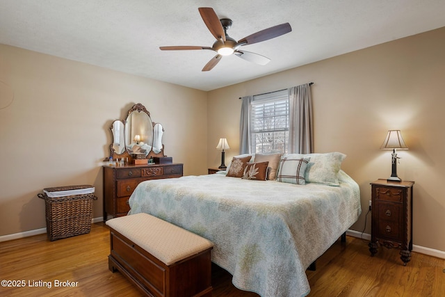 bedroom featuring a ceiling fan, baseboards, and wood finished floors