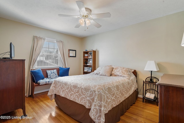 bedroom with baseboards, ceiling fan, and light wood finished floors