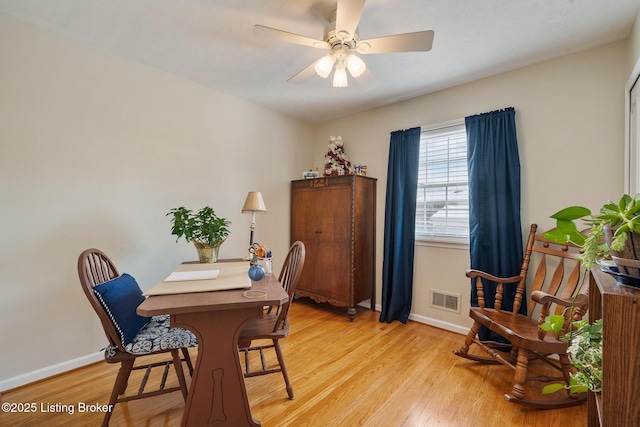 dining space featuring light wood-style flooring, visible vents, ceiling fan, and baseboards