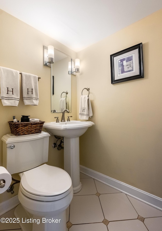 bathroom featuring tile patterned flooring, baseboards, and toilet