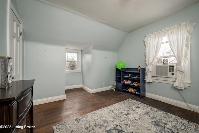 interior space featuring cooling unit, baseboards, lofted ceiling, and wood finished floors