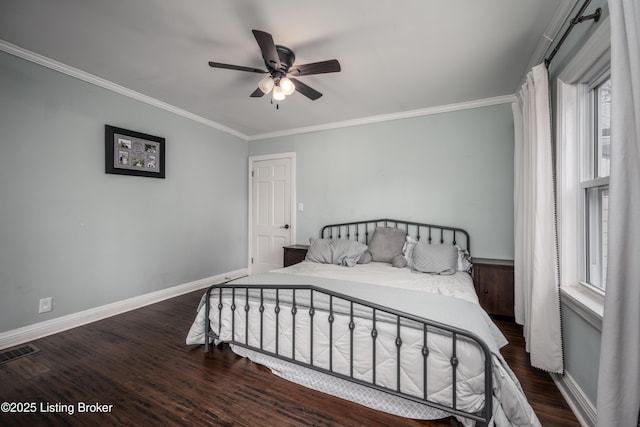 bedroom featuring visible vents, ornamental molding, wood finished floors, baseboards, and ceiling fan