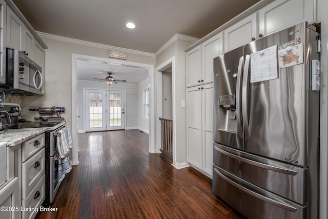 kitchen featuring dark wood-style floors, stainless steel appliances, light stone counters, and ornamental molding