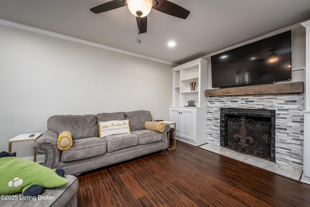 living area featuring crown molding, a stone fireplace, recessed lighting, wood finished floors, and a ceiling fan