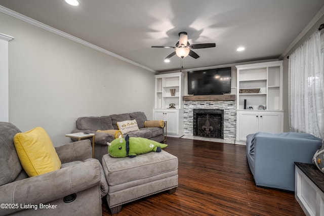 living room with a ceiling fan, wood finished floors, recessed lighting, ornamental molding, and a tiled fireplace