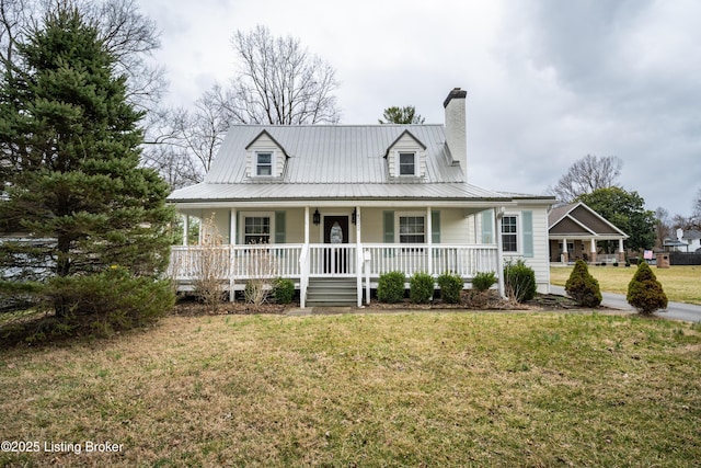 view of front of home with a front lawn, a chimney, covered porch, and metal roof