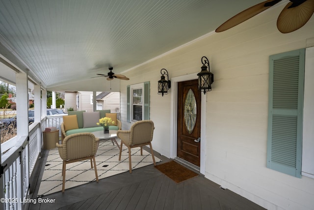 wooden terrace with covered porch and a ceiling fan