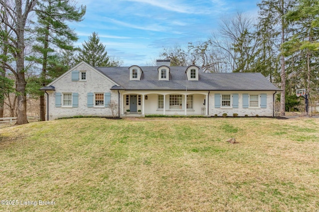 view of front of property featuring brick siding, a porch, and a front lawn