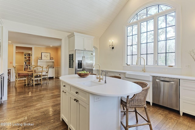 kitchen featuring hardwood / wood-style floors, lofted ceiling, plenty of natural light, a sink, and stainless steel appliances