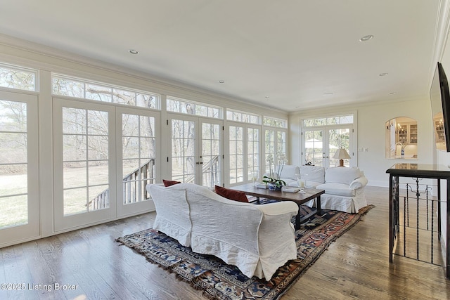 living area featuring ornamental molding, wood finished floors, recessed lighting, french doors, and baseboards