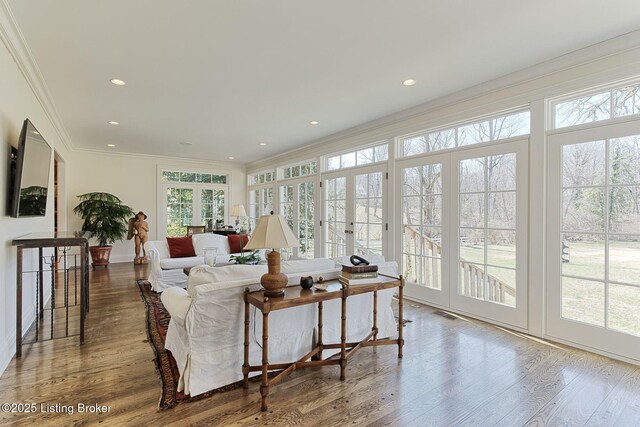 living area with recessed lighting, wood finished floors, and ornamental molding