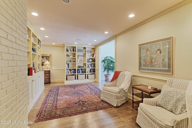 living area featuring recessed lighting, crown molding, and light wood finished floors