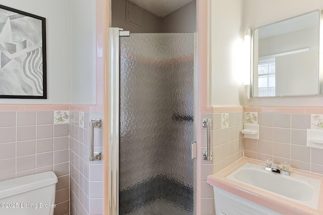 full bath featuring toilet, tile walls, a stall shower, and vanity