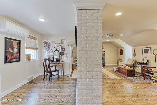 interior space featuring visible vents, lofted ceiling, an AC wall unit, and wood finished floors