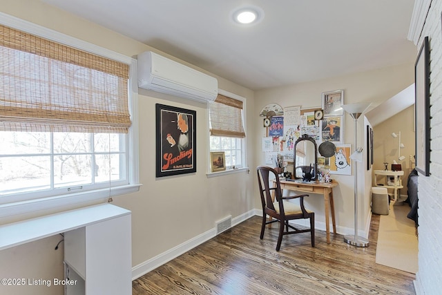 office space with visible vents, baseboards, wood finished floors, and a wall mounted AC