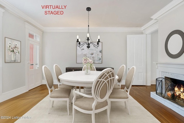 dining area with crown molding, a premium fireplace, and wood finished floors