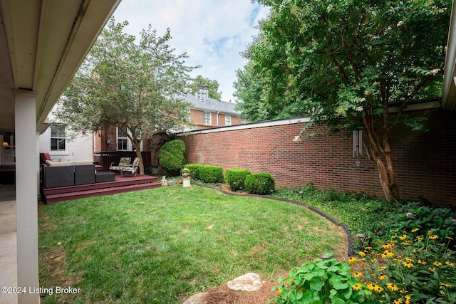 view of yard featuring outdoor lounge area, fence, and a deck