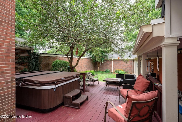 wooden terrace with outdoor lounge area, fence, and a hot tub