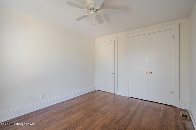 unfurnished bedroom with wood finished floors, a ceiling fan, visible vents, baseboards, and a closet