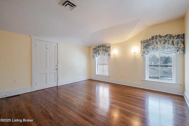 unfurnished room featuring lofted ceiling, visible vents, and wood finished floors