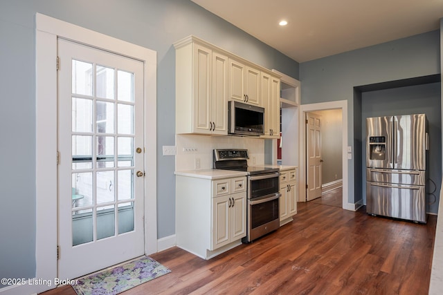 kitchen featuring stainless steel appliances, dark wood-style flooring, light countertops, and tasteful backsplash