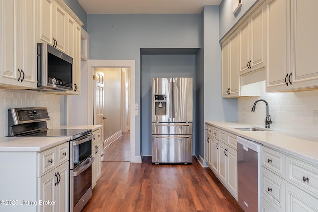 kitchen with dark wood-style floors, appliances with stainless steel finishes, light countertops, and a sink