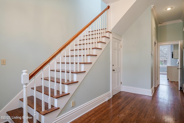 staircase with crown molding, wood finished floors, and baseboards