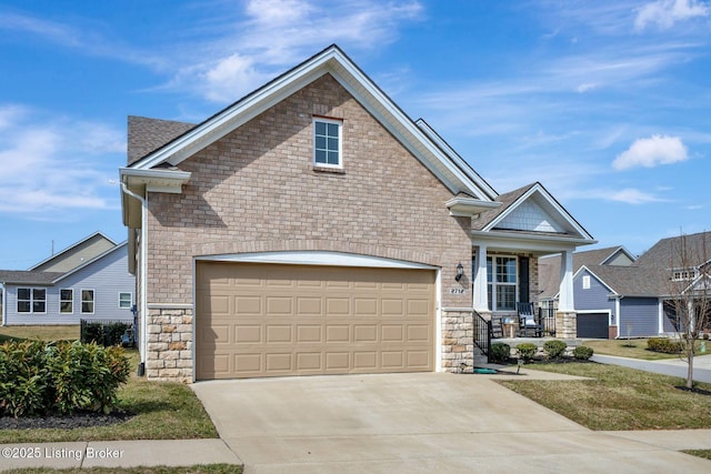 view of front of house with driveway, covered porch, a garage, and stone siding