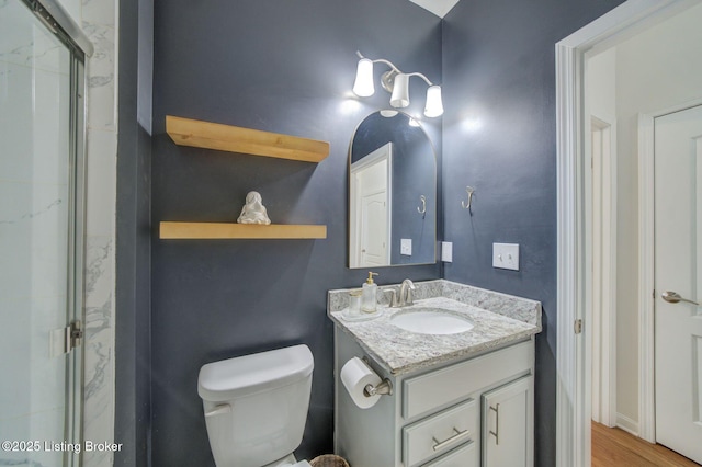 full bath featuring toilet, a shower stall, and vanity