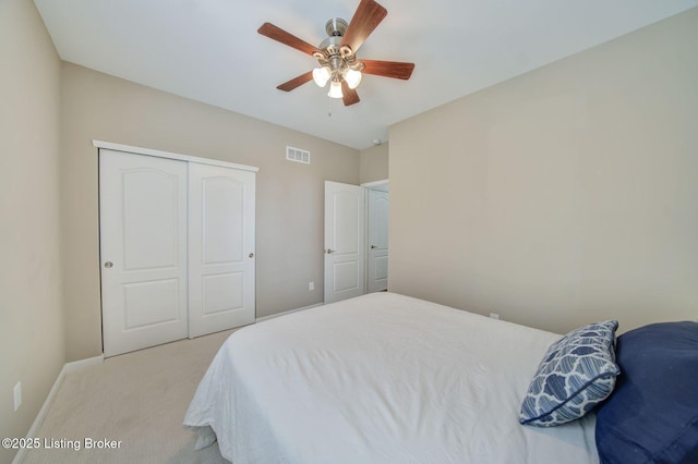 bedroom with light carpet, baseboards, visible vents, ceiling fan, and a closet