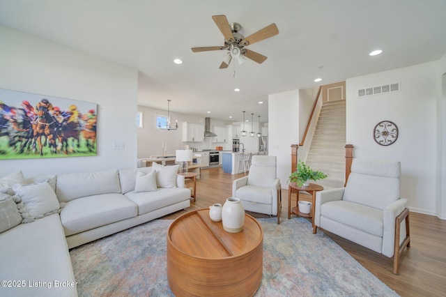 living area featuring stairway, recessed lighting, visible vents, and light wood-style floors