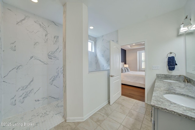 ensuite bathroom with connected bathroom, marble finish floor, a sink, and a marble finish shower