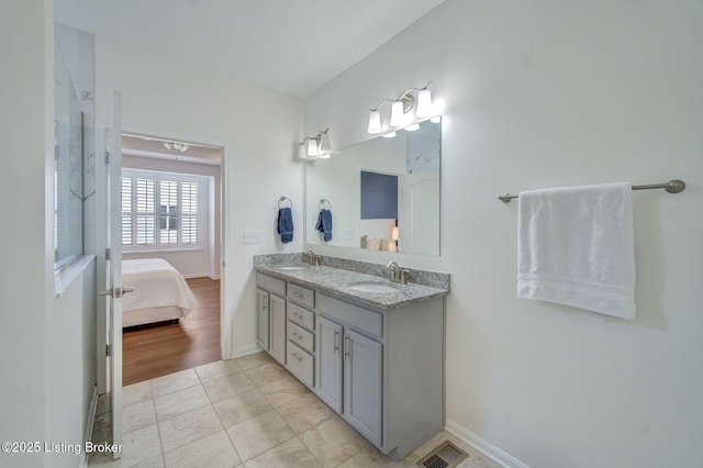 bathroom with double vanity, visible vents, a sink, and ensuite bathroom