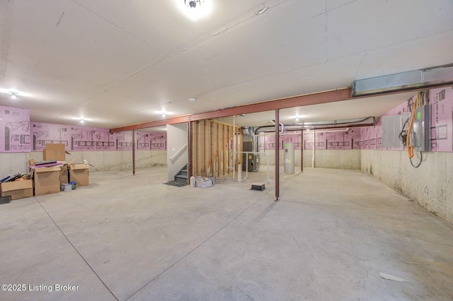 unfinished below grade area featuring water heater, stairway, and electric panel