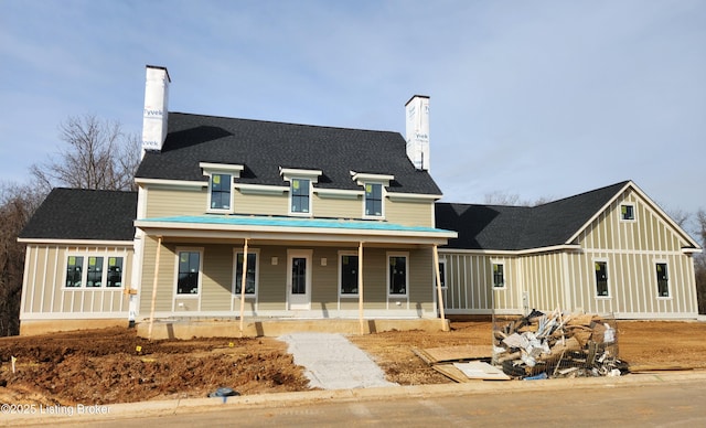 view of front of property featuring roof with shingles, a porch, a chimney, and board and batten siding